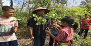 The student learning how to plant the trees.